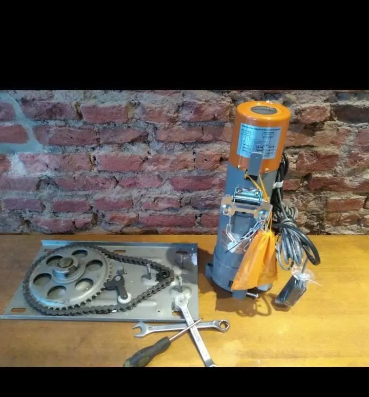 Motor naranja con cadena y herramientas sobre mesa, buena luz